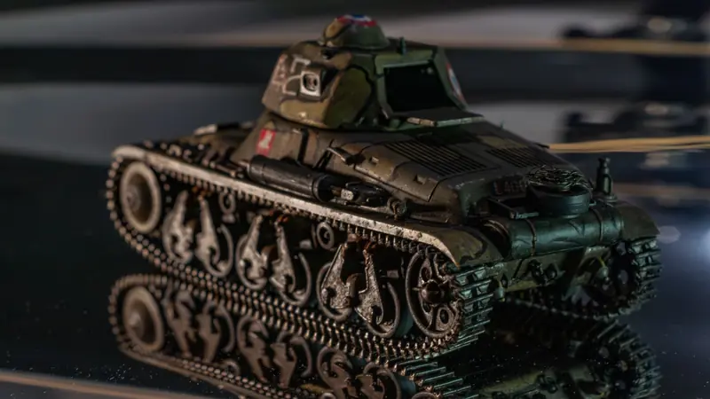 Close-up of a detailed miniature tank model reflecting on a surface, showcasing military collectibles