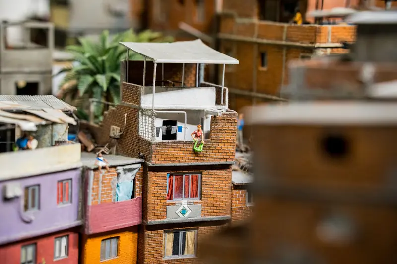 A vibrant miniature display of a colorful urban rooftop scene, complete with tiny figurines
