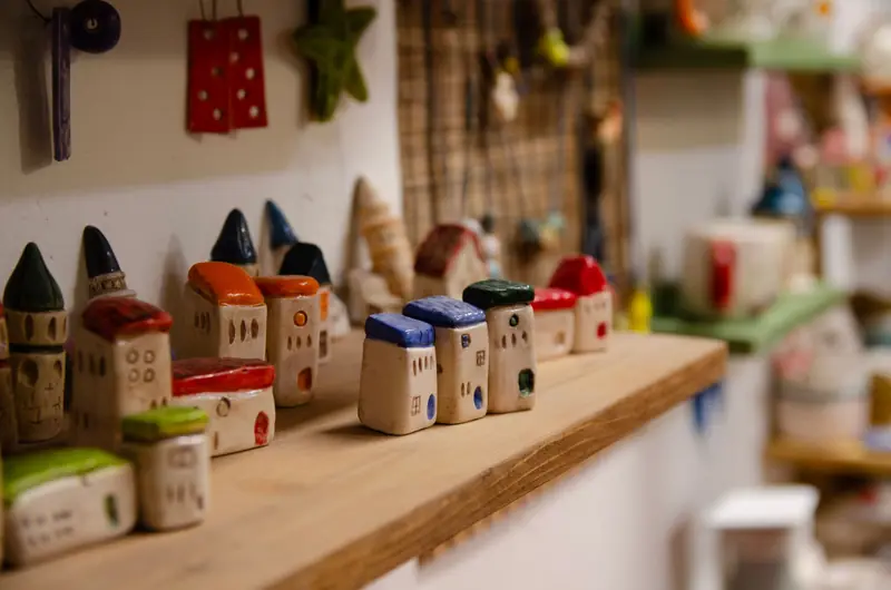 Charming collection of colorful ceramic house miniatures on a shelf in an artisan shop